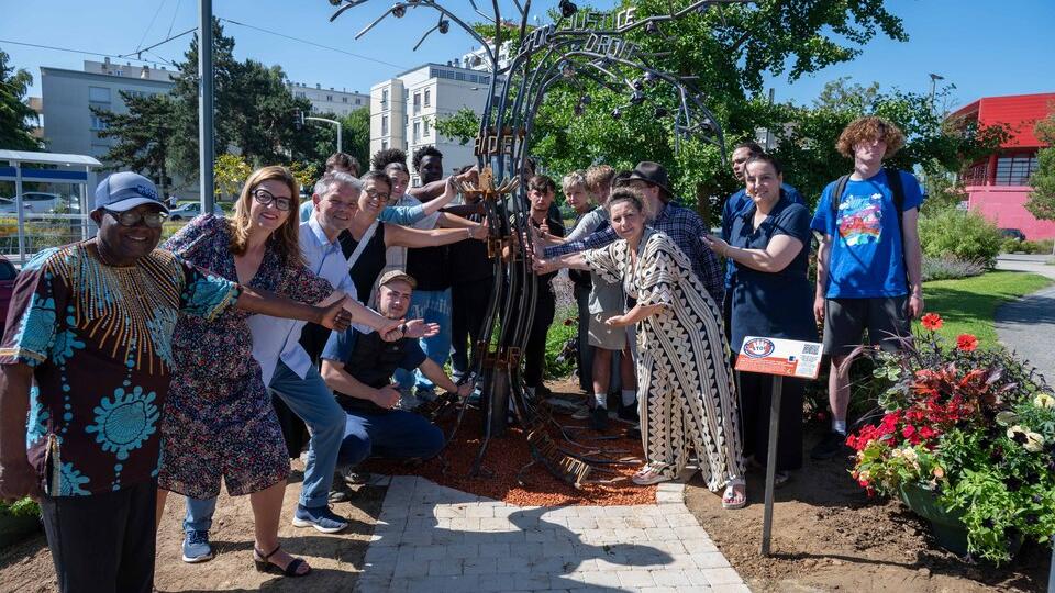 Photo de groupe devant la sculpture des violences conjuguales
